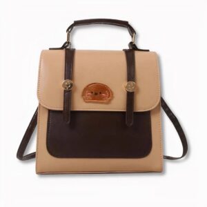 Sac à dos type cartable marron et beige avec un écusson de visage de chien sur le devant, sur fond gris clair